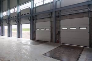 A row of loading bays in a warehouse with open and closed doors